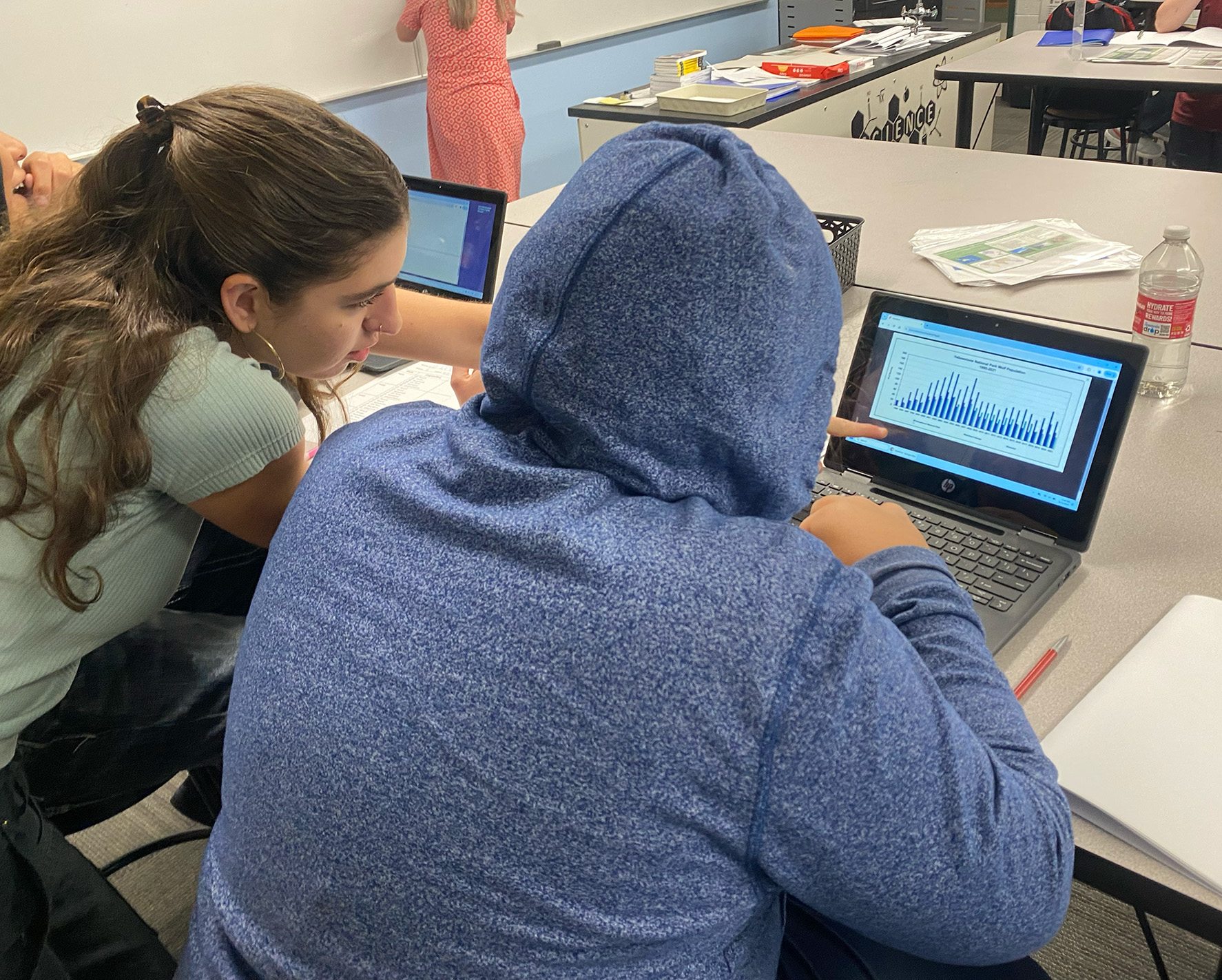 Kiri teaching 7th grader on computer.